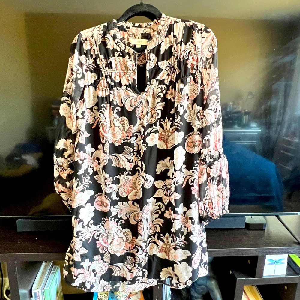 Loose dress, long sleeves with details.